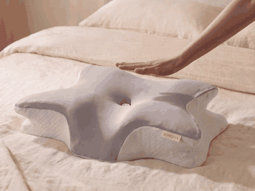 Une main appuie sur l'oreiller Somélya puis se retire : la mousse reprend sa forme